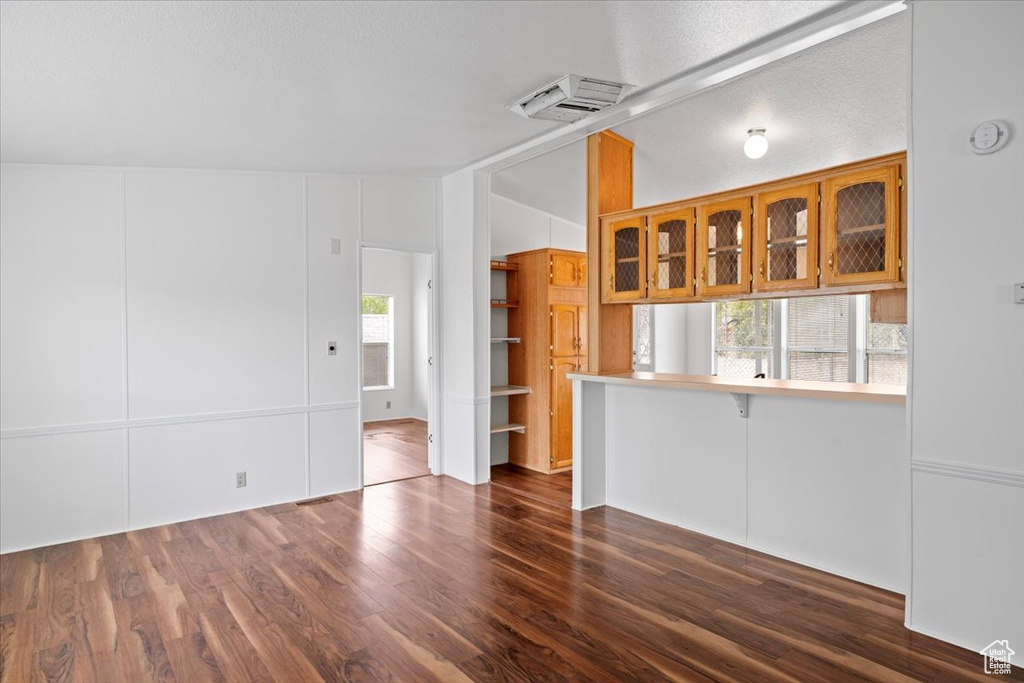 Unfurnished living room with dark wood-type flooring