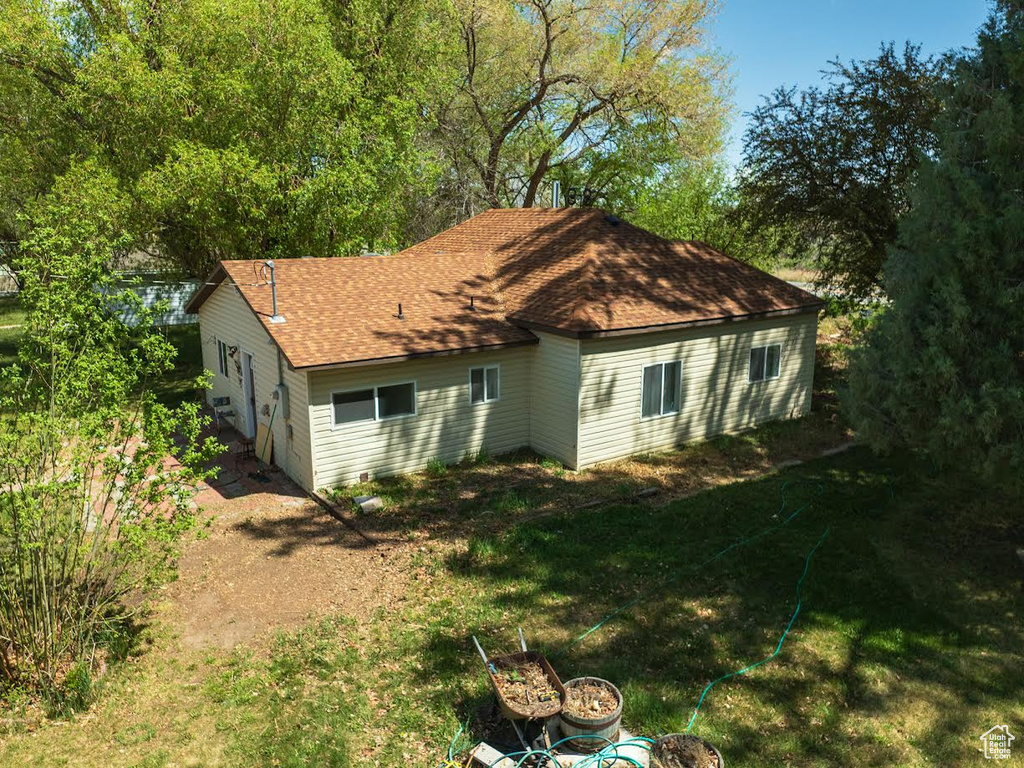 View of home\'s exterior with roof with shingles and a yard