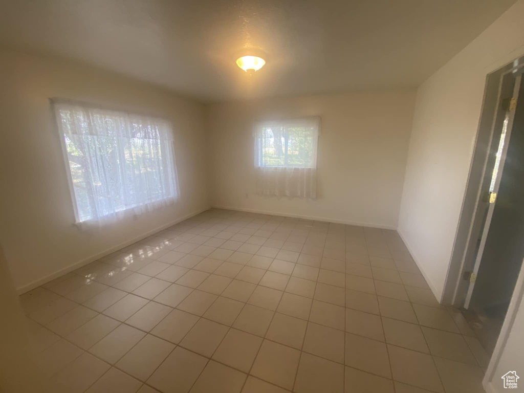 Spare room featuring light tile patterned floors and baseboards