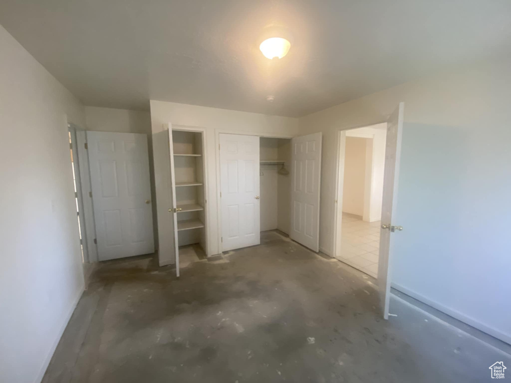 Unfurnished bedroom with concrete floors