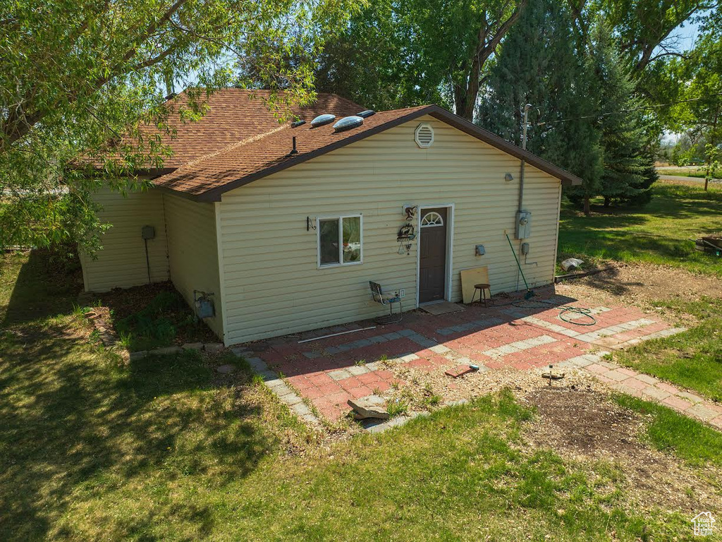 Back of property with a patio and a lawn
