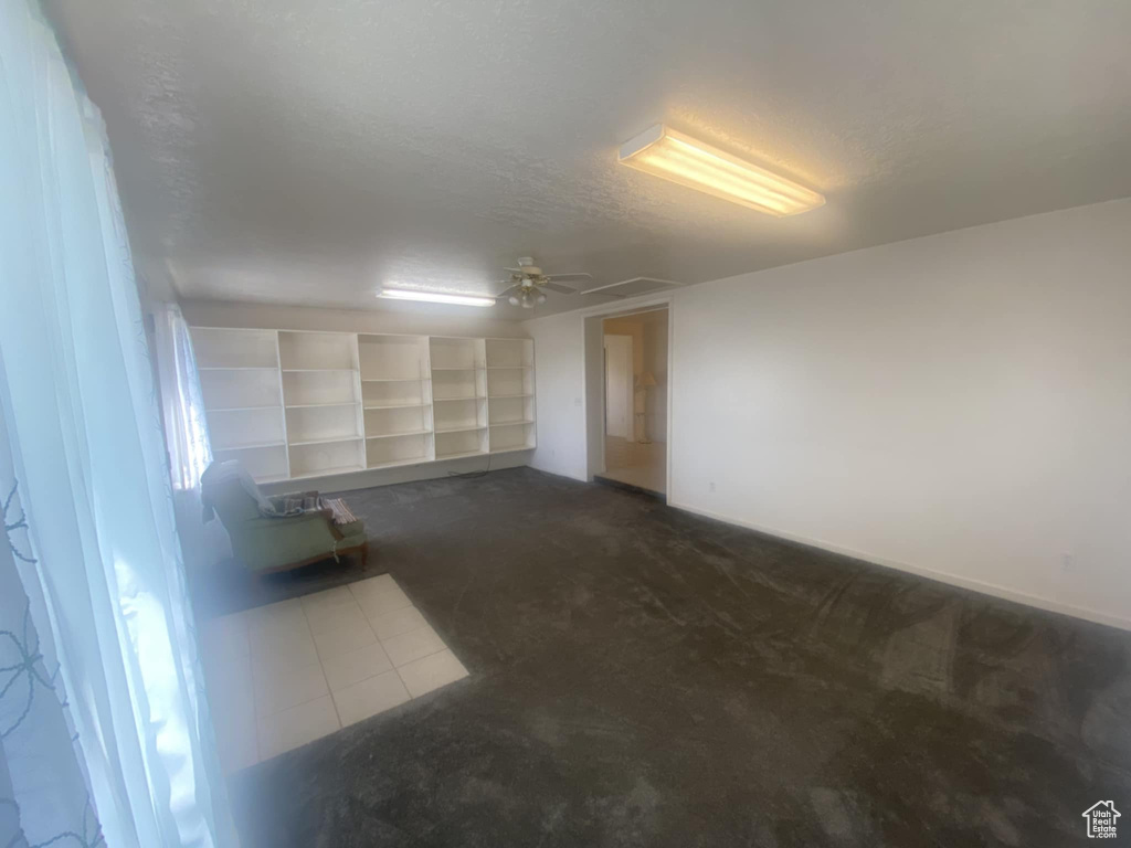 Spare room with dark colored carpet and dark tile patterned floors
