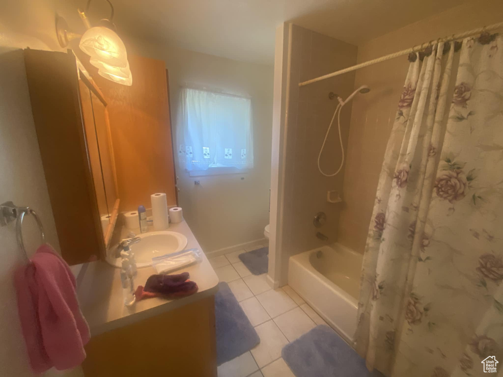 Full bathroom with tile patterned flooring, vanity, shower / bathtub combination with curtain, and toilet