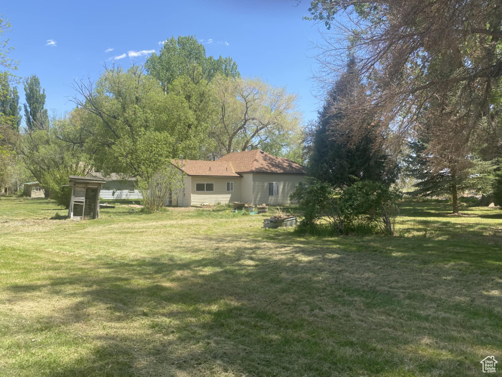 View of grassy yard featuring an outbuilding