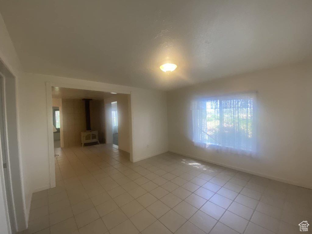 Empty room with plenty of natural light, baseboards, and light tile patterned floors