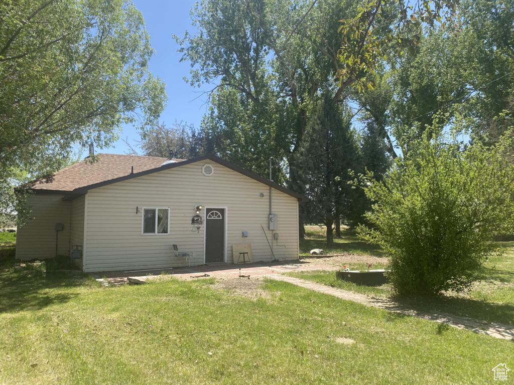 Rear view of house with a lawn and a shingled roof