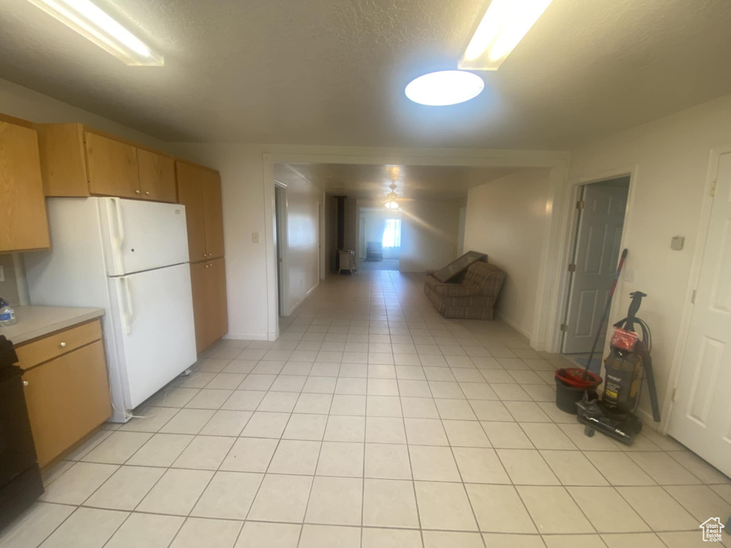 Kitchen featuring light countertops, freestanding refrigerator, and light tile patterned floors