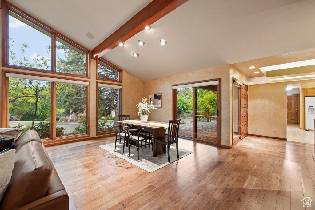 Dining area featuring beamed ceiling, light wood finished floors, and high vaulted ceiling