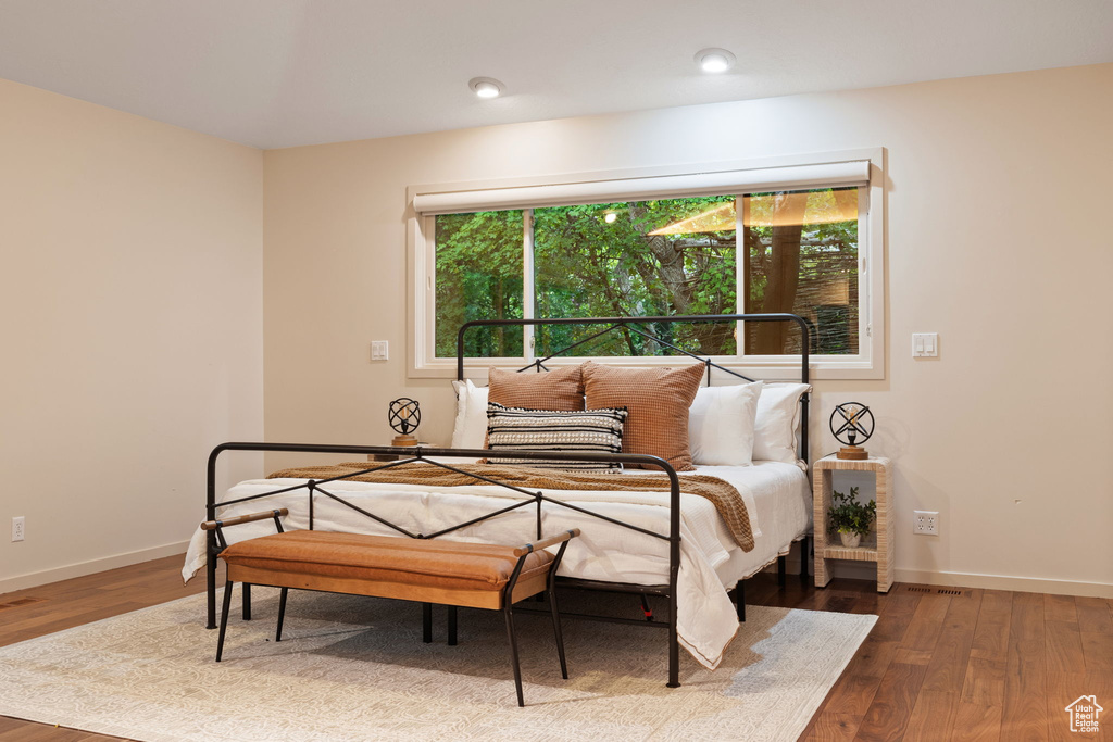 Bedroom with wood finished floors, baseboards, and recessed lighting
