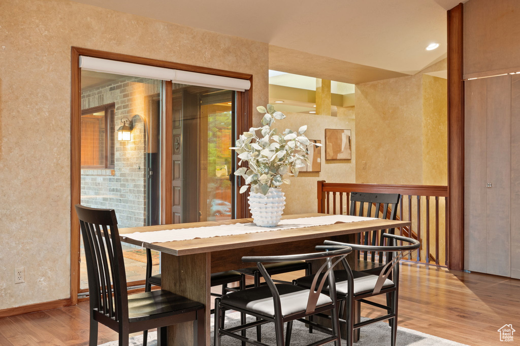 Dining room featuring a textured wall, baseboards, and wood finished floors