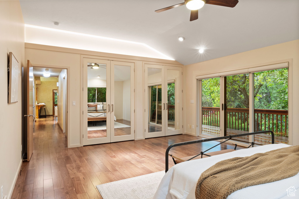 Bedroom with wood finished floors, french doors, multiple windows, and access to exterior
