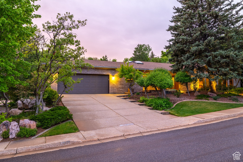 Ranch-style house with an attached garage, brick siding, and driveway
