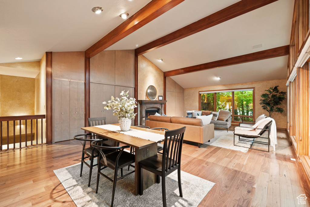 Dining space featuring recessed lighting, lofted ceiling with beams, light wood-type flooring, and a large fireplace
