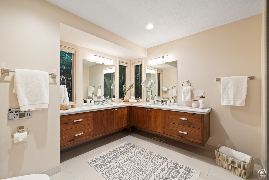 Full bath featuring baseboards, tile patterned flooring, vanity, and visible vents
