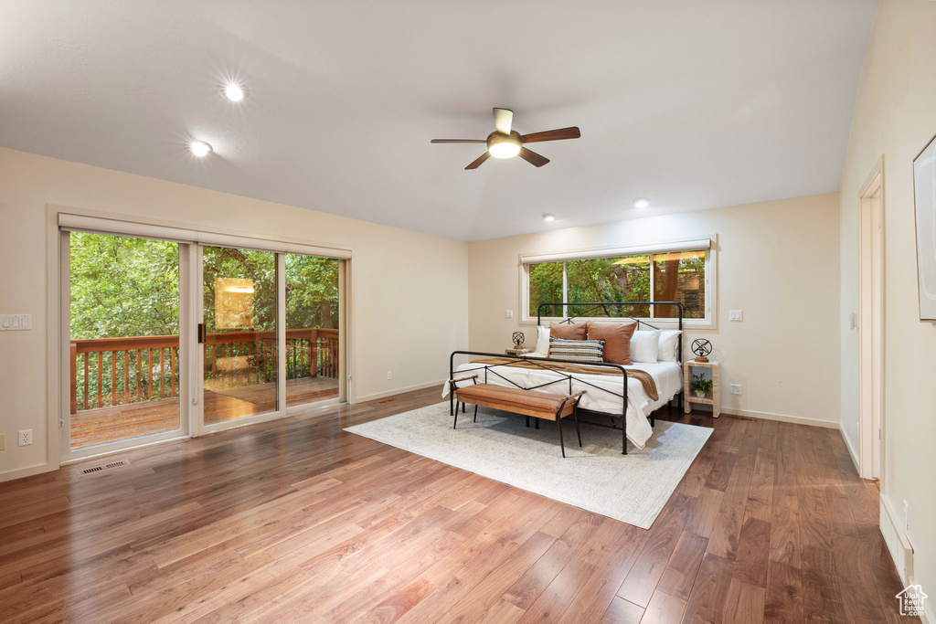 Bedroom with multiple windows, visible vents, wood finished floors, and access to exterior