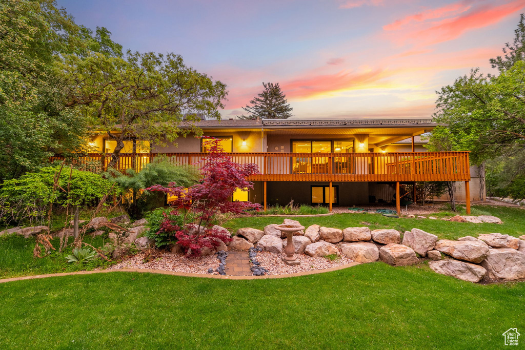 Back of property with a yard and a wooden deck