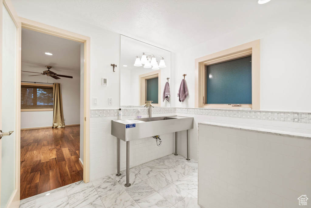Bathroom featuring a ceiling fan, tile walls, wainscoting, and recessed lighting