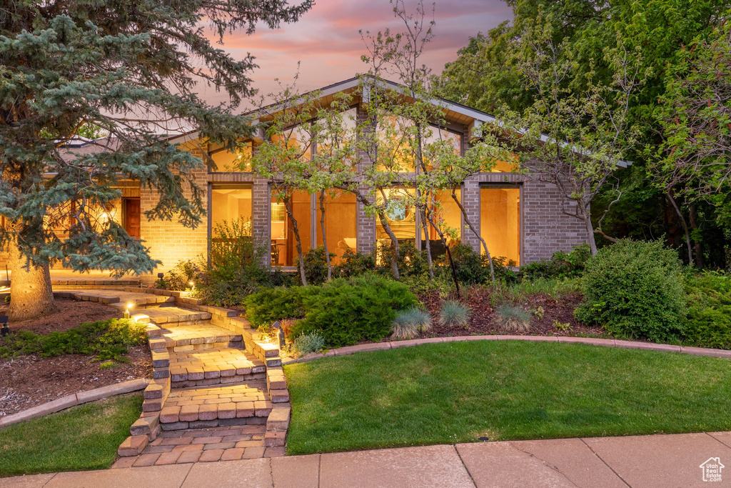 View of front of home with a front yard and brick siding