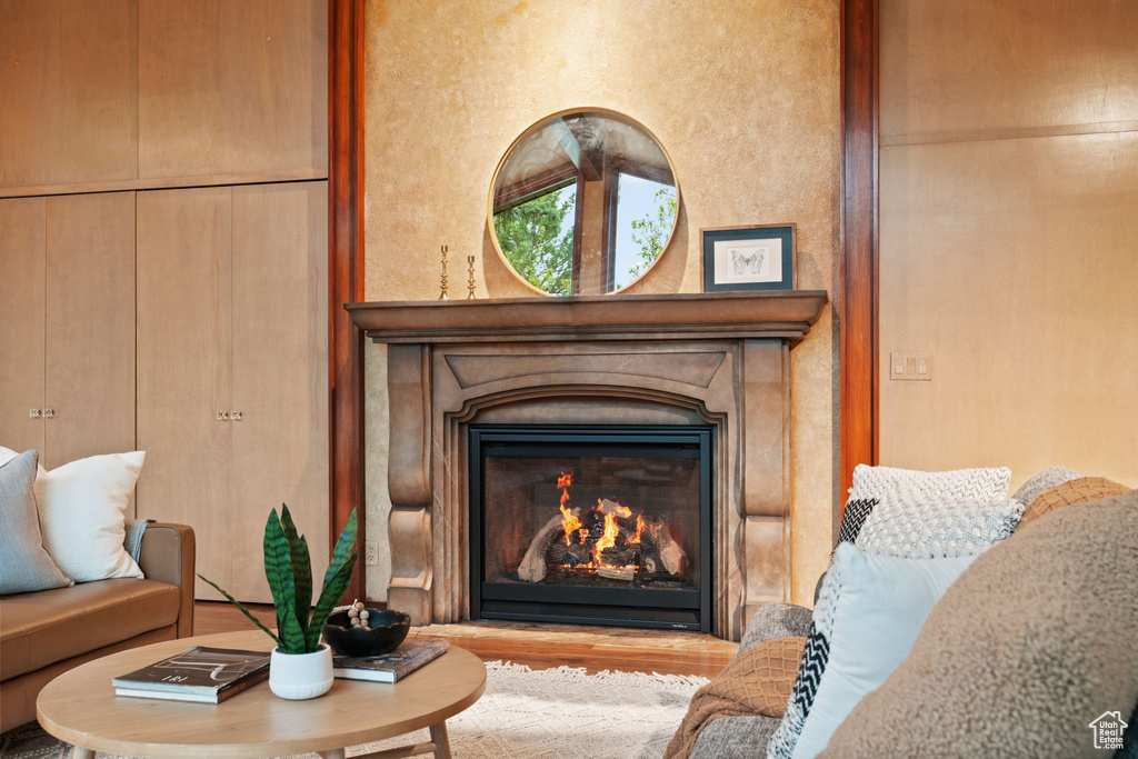 Room details with a glass covered fireplace and wood finished floors