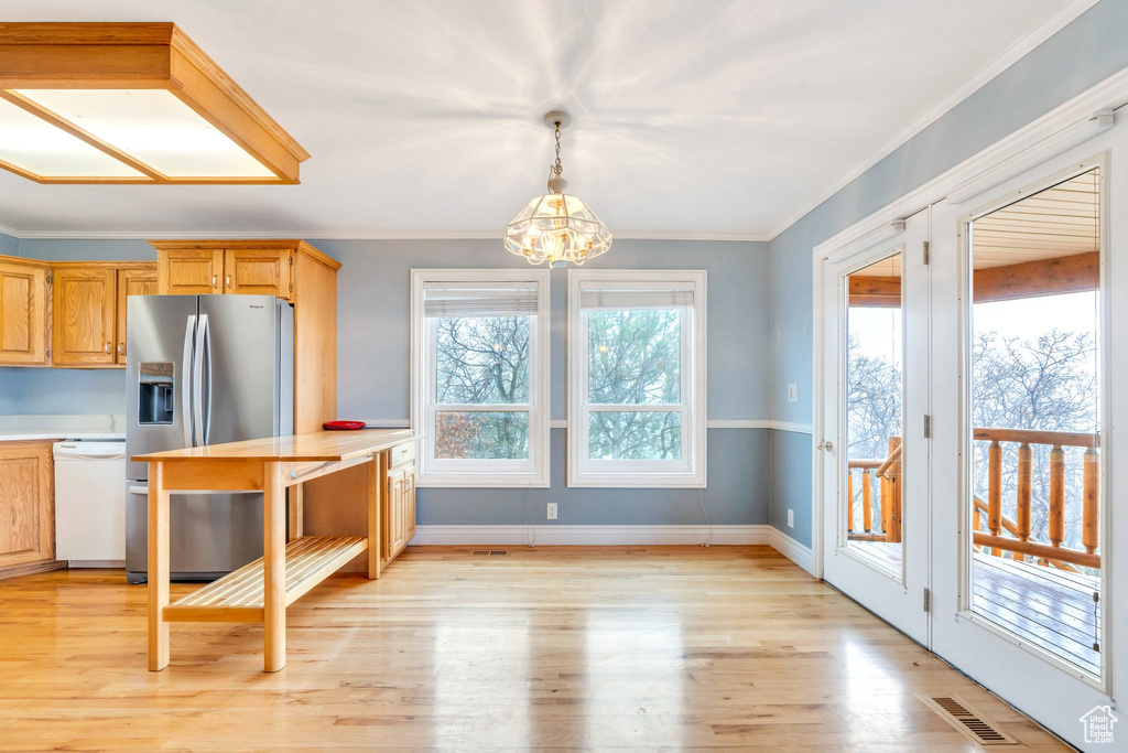 Kitchen featuring stainless steel refrigerator with ice dispenser, dishwasher, a chandelier, light wood-type flooring, and light countertops