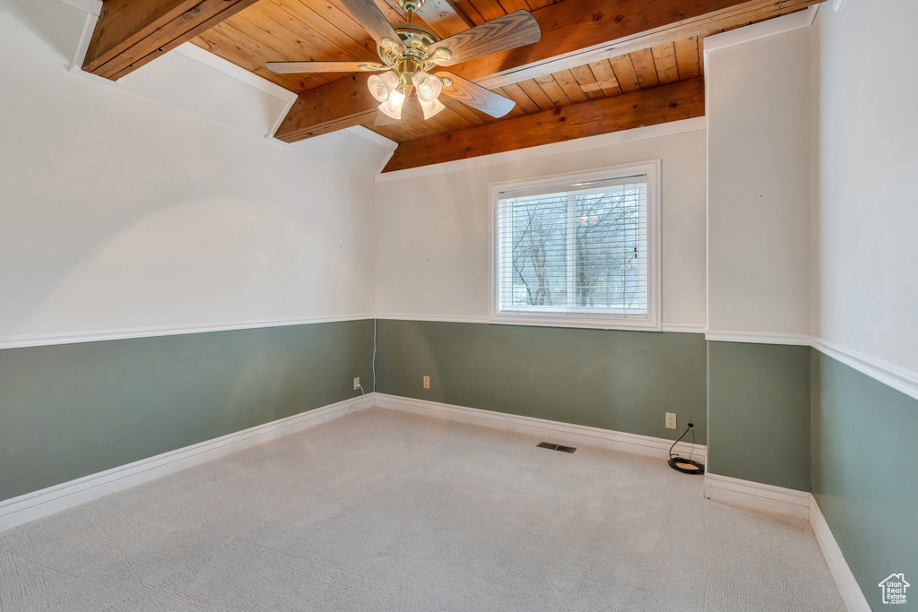 Spare room with wooden ceiling, carpet, a ceiling fan, beamed ceiling, and baseboards