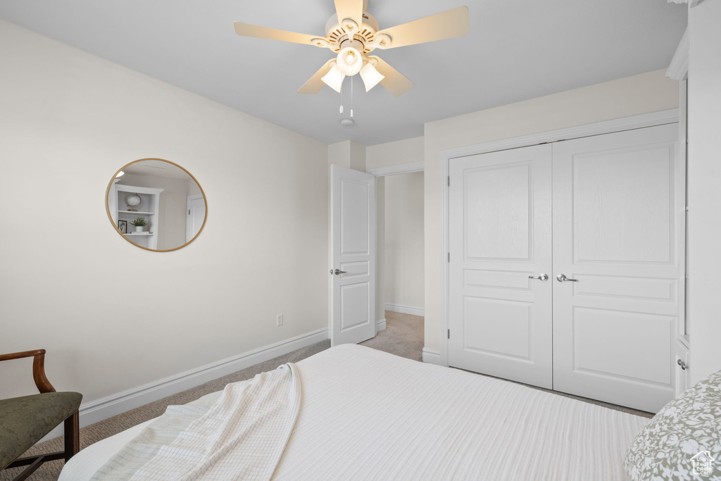 Bedroom with carpet, baseboards, a closet, and ceiling fan