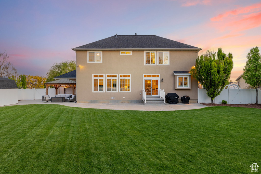 Back of house at dusk featuring an outdoor hangout area, a patio area, a gazebo, and entry steps