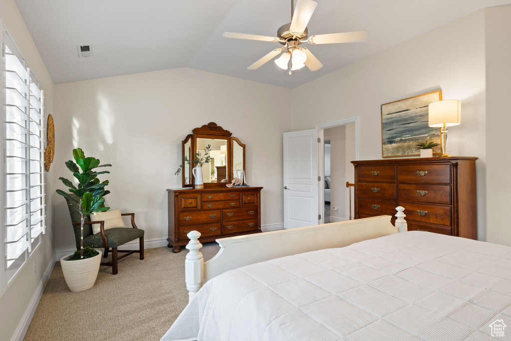 Carpeted bedroom featuring lofted ceiling, baseboards, and a ceiling fan