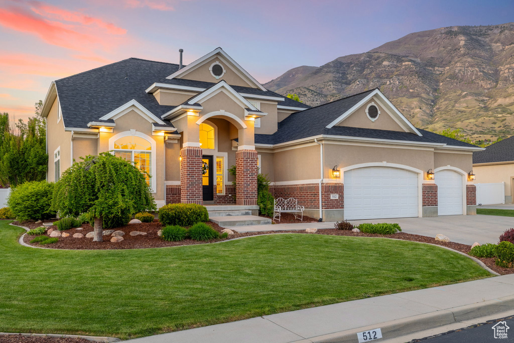 View of front of home with a front yard, a garage, driveway, and stucco siding