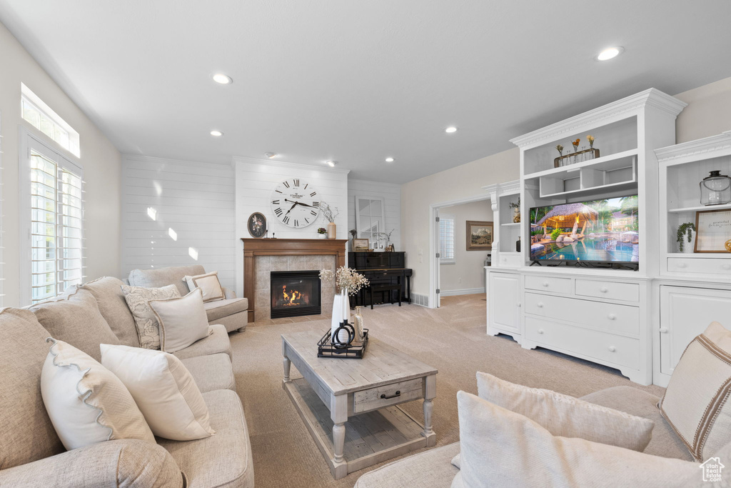 Living room with recessed lighting, light carpet, a fireplace, and baseboards