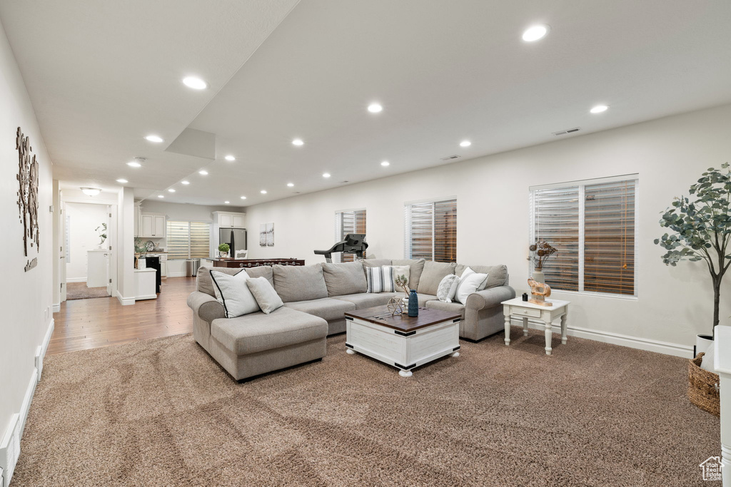 Living room featuring recessed lighting, baseboards, and light wood-type flooring