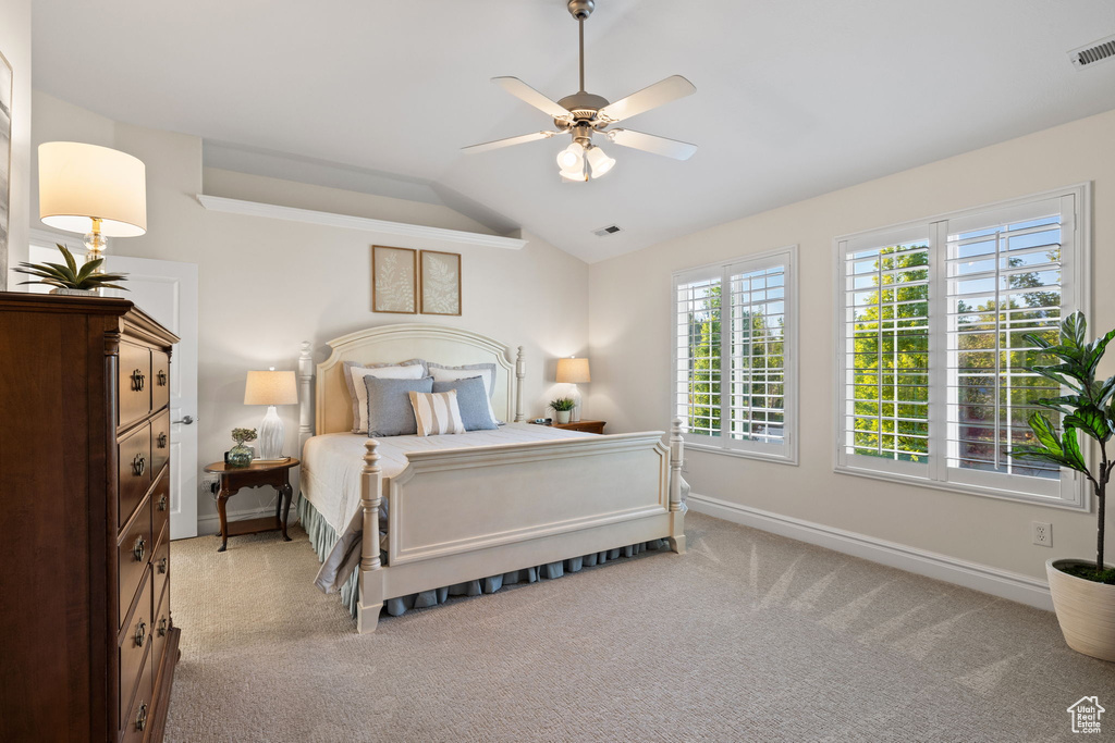 Bedroom with vaulted ceiling, carpet, baseboards, and a ceiling fan