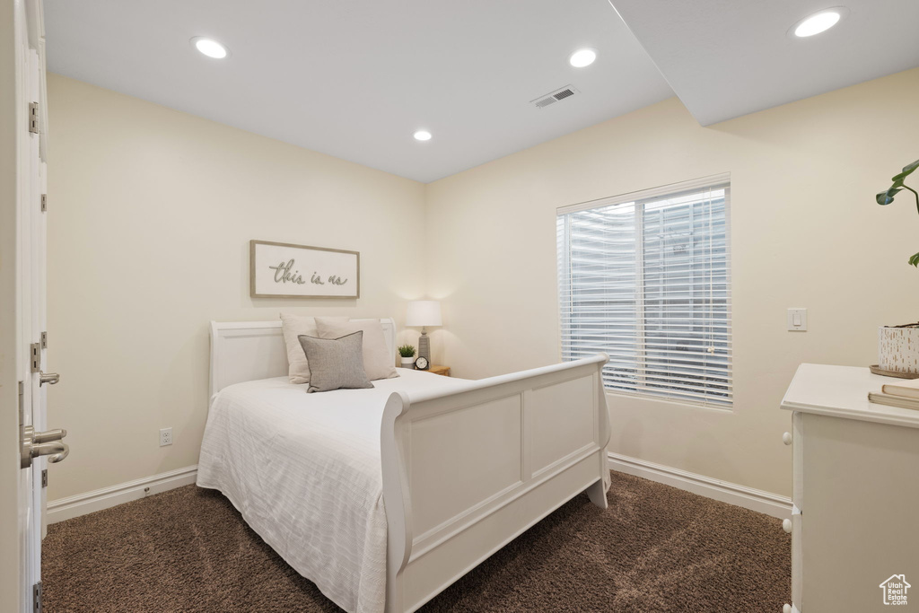 Bedroom with dark carpet, baseboards, and recessed lighting