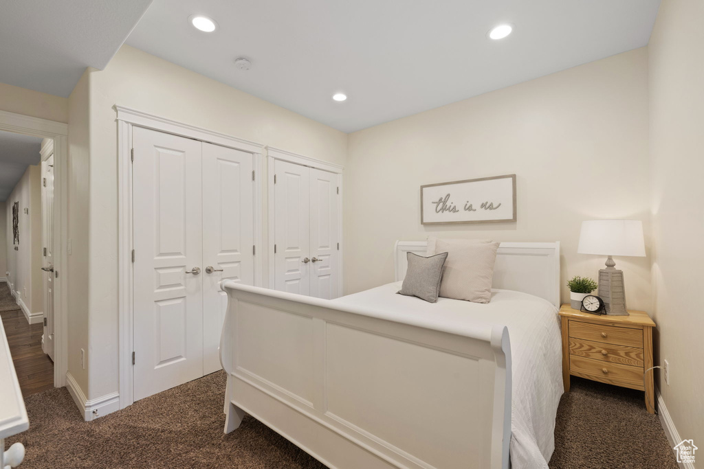 Bedroom featuring multiple closets, dark carpet, baseboards, and recessed lighting