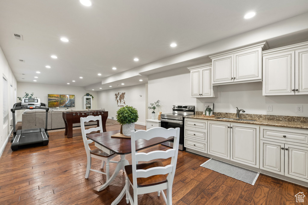 Kitchen featuring stainless steel electric range oven, a sink, dark wood-style floors, recessed lighting, and light stone counters