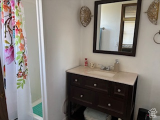 Bathroom with vanity, a shower with curtain, and baseboards