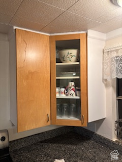 Kitchen view of dark countertops and a drop ceiling