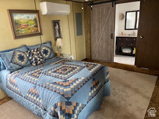 Carpeted bedroom featuring a wall mounted AC, a barn door, and electric panel