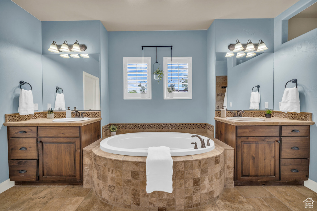 Bathroom with a bath and two vanities