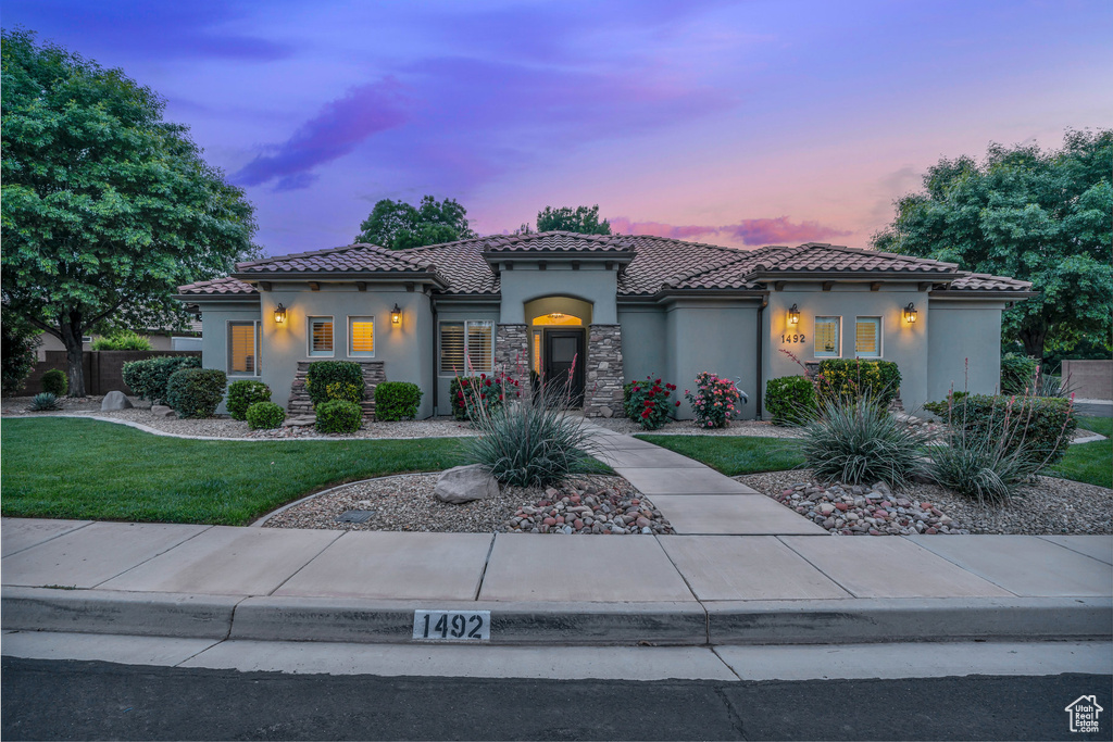 Mediterranean / spanish-style home featuring stucco siding, a front yard, and a tiled roof