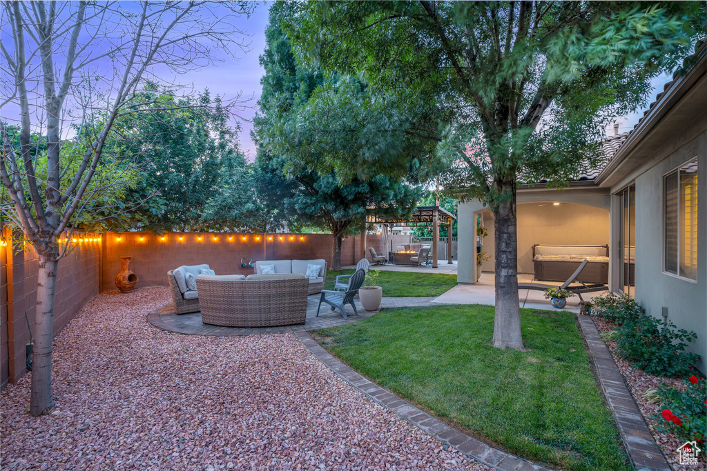 Yard at dusk featuring an outdoor living space and a patio