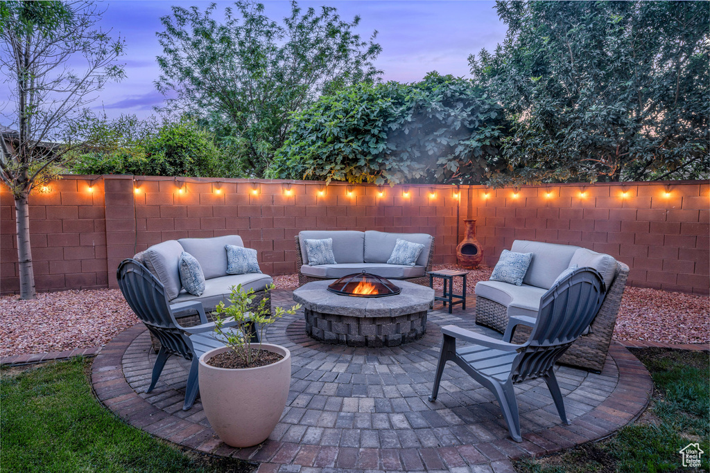 View of patio / terrace with an outdoor living space with a fire pit and a fenced backyard
