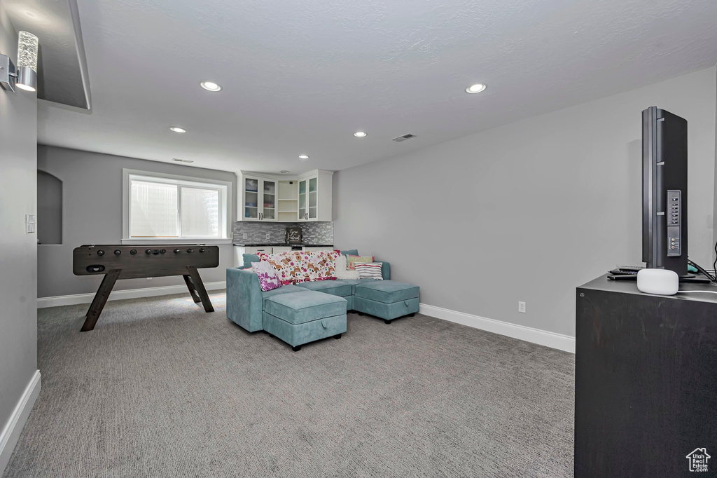 Carpeted living area featuring baseboards and recessed lighting