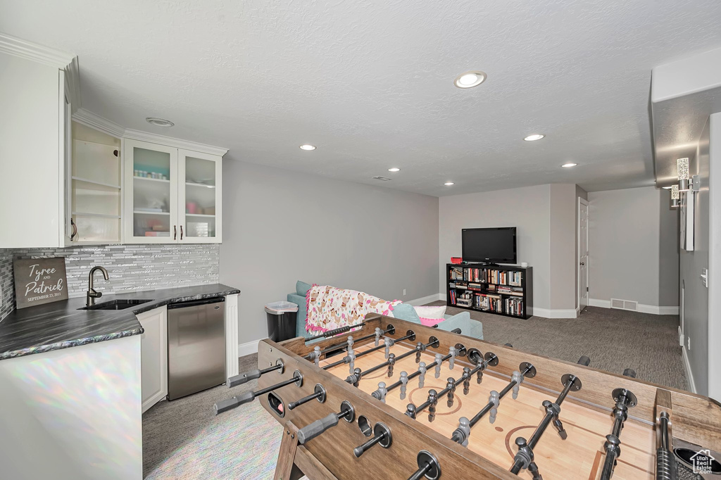 Playroom with baseboards, recessed lighting, light carpet, and wet bar