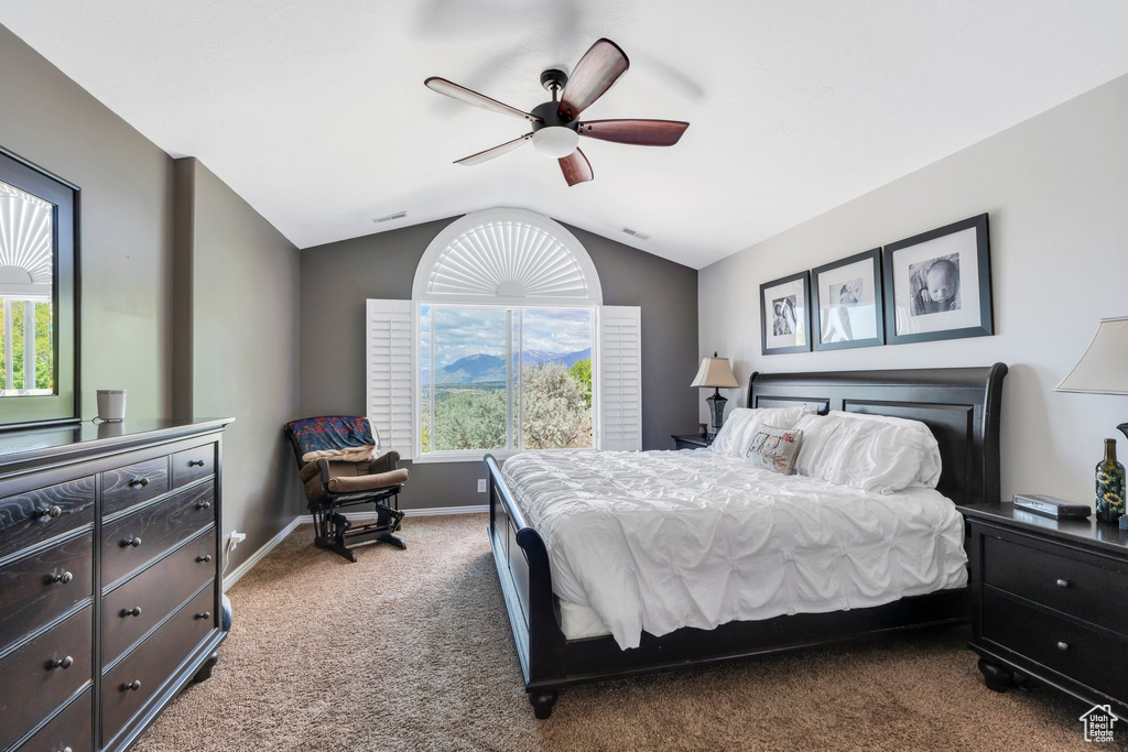 Carpeted bedroom featuring vaulted ceiling, baseboards, and ceiling fan
