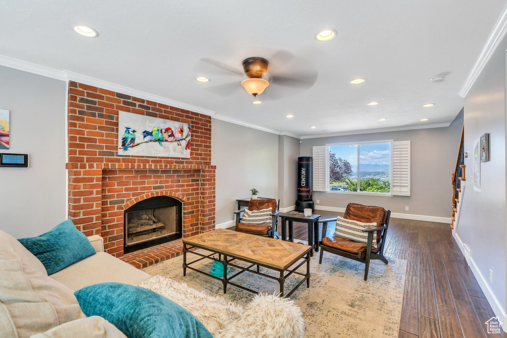 Living area featuring baseboards, ornamental molding, recessed lighting, a fireplace, and a ceiling fan