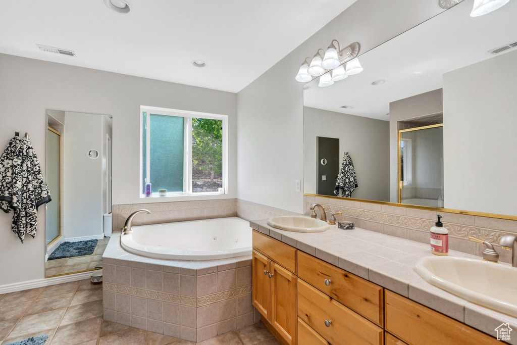 Bathroom with a stall shower, a jetted tub, double vanity, and tile patterned floors