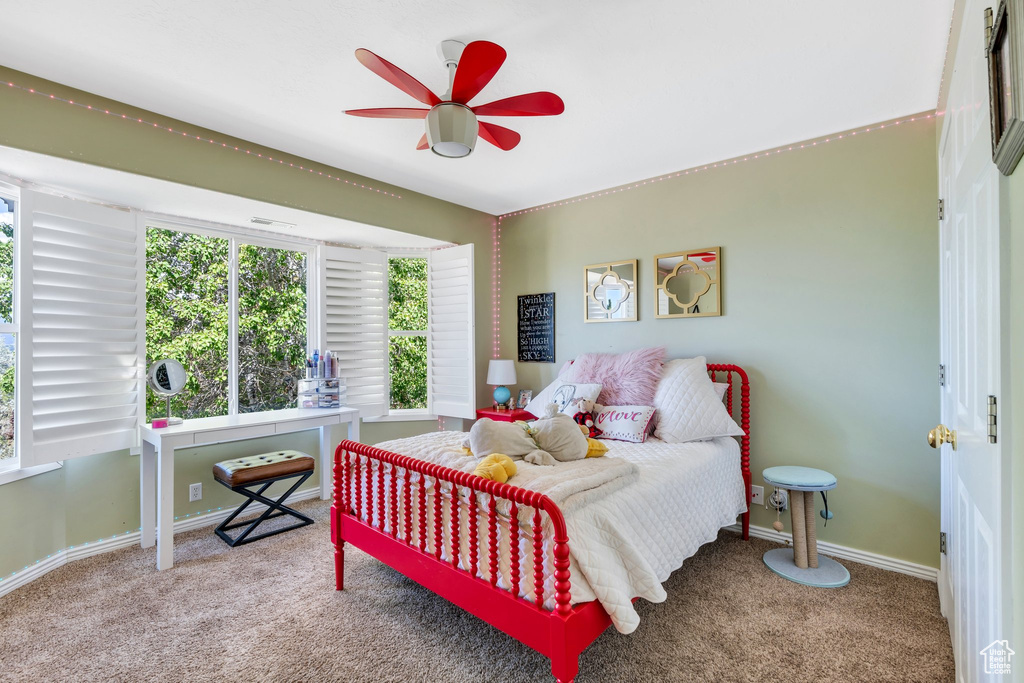Carpeted bedroom with multiple windows and baseboards