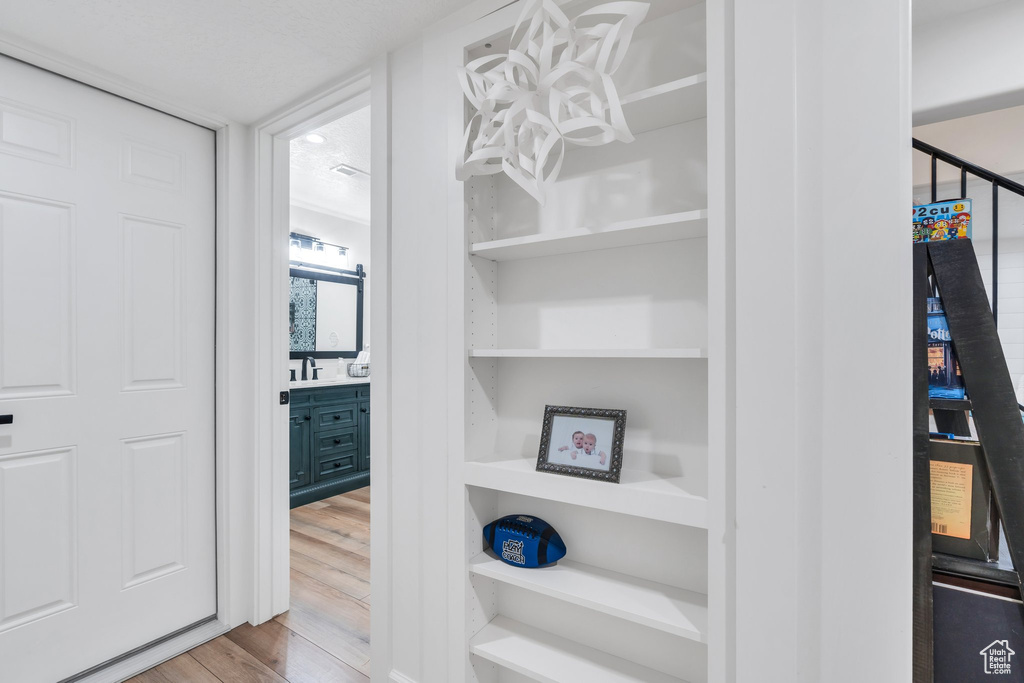 Walk in closet with wood finished floors and a sink