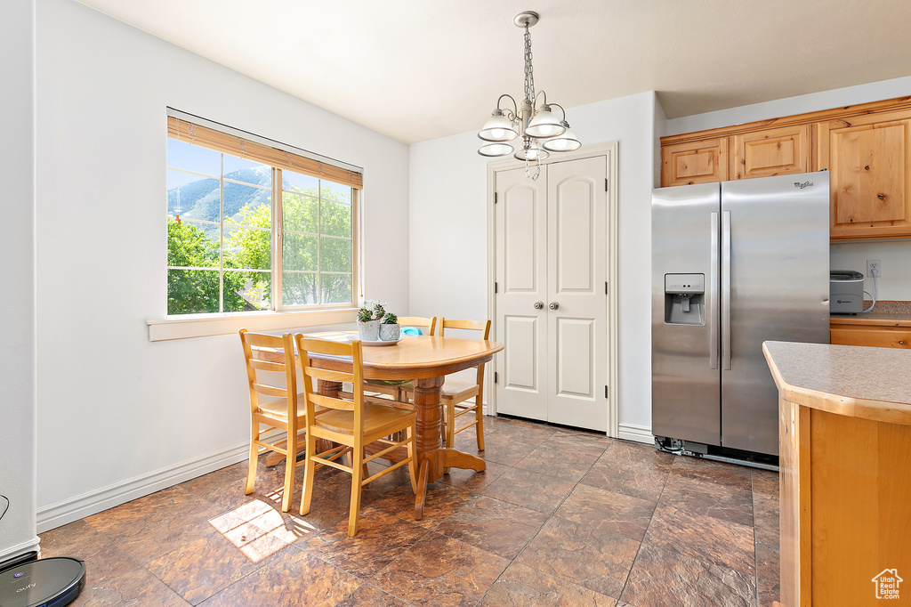 Dining area featuring a chandelier, dark stone finish flooring, and baseboards